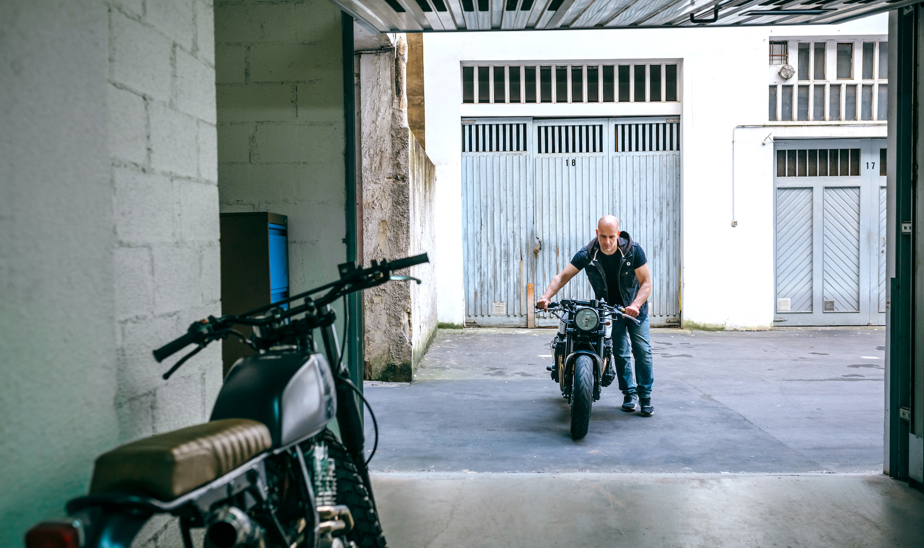 Man wheeling bike into garage